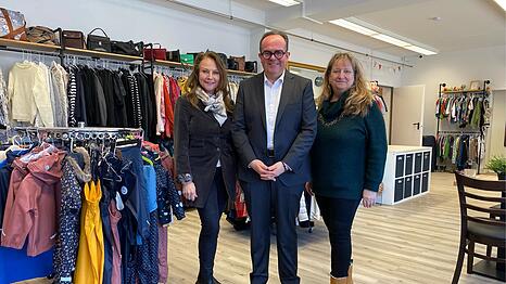 OB-Kandidat Clemens Baumg&auml;rtner (CSU) vor viel Secondhand-Klamotten im neuen Nachbarschaftstreff  "Giesinger Herz" &ndash; zwischen den CSU-Stadtr&auml;tinnen Ulrike Grimm (l.) und Alexandra Ga&szlig;mann.