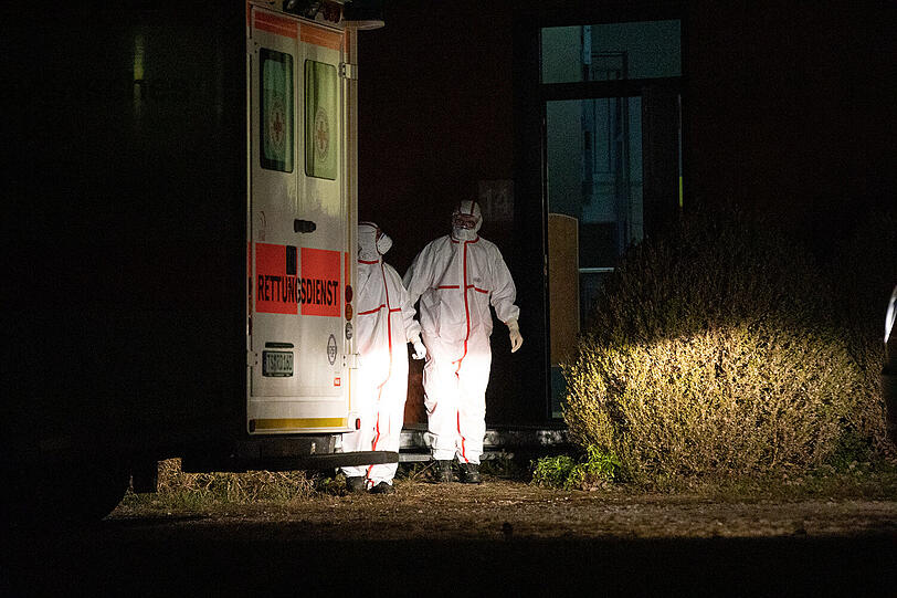 Das Foto zeigt BRK-Einsatzkräfte in Schutzanzügen bei einem Einsatz am Donnerstagabend. Ob es in der Gemeinde Siegsdorf einen Verdachtsfall gab, ist bislang nicht bekannt.