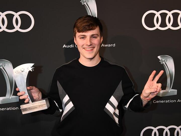 Tom Gregory steht mit seinem Preis auf dem roten Teppich. Foto: Felix Hörhager/dpa
