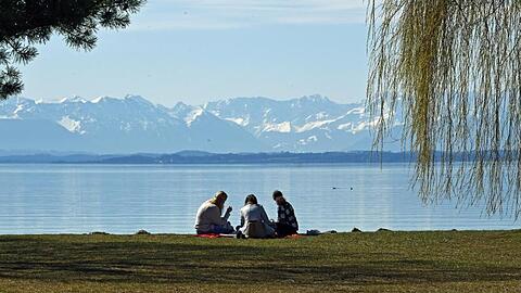 Drei Mädchen sitzen am See.