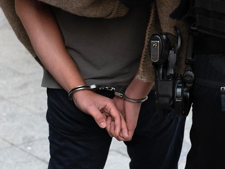 Polizisten führen einen Verdächtigen nach einer Razzia gegen kriminelle Mitglieder arabischer Großfamilien ab.