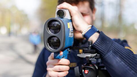 Ein Polizist schaut während des sogenannten Blitzermarathons durch ein Laserhandmessgerät.