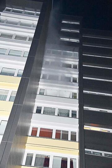 Rauch kommt aus einem der Fenster des Hochhauses.