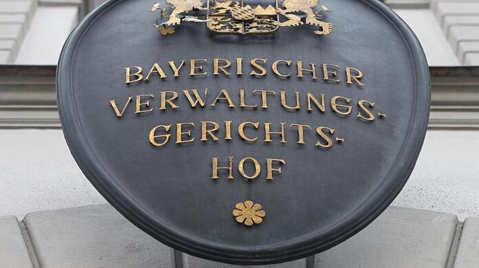 Ein Schild mit der Aufschrift "Bayerischer Verwaltungsgerichtshof" hängt an der Fassade des Gerichtshofes.