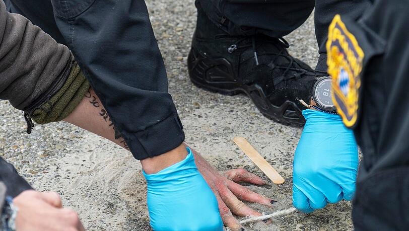Speziell geschulte Polizisten versuchten, die Hände von Demonstranten von der Straße zu lösen.