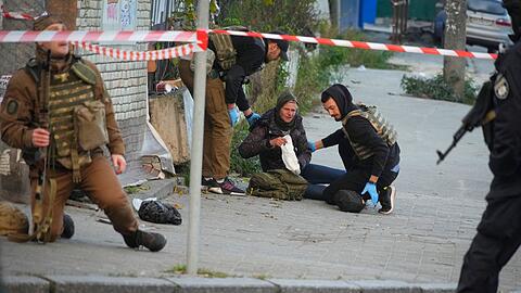 Sanitäter helfen einer verletzten Frau nach dem Beschuss von Gebäuden in Kiew durch eine Drohne.
