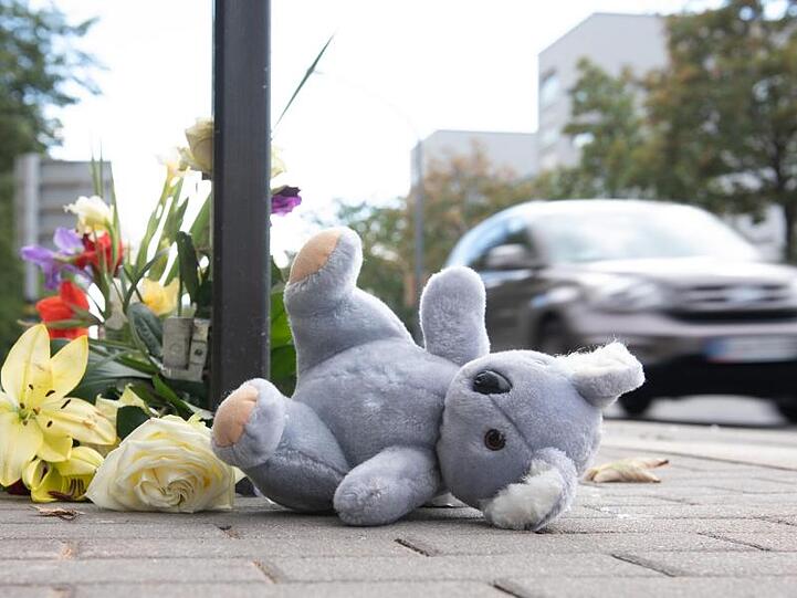 Ein Plüschtier und Blumen liegen nach dem schweren Verkehrsunfall am Unfallort in Dresden.