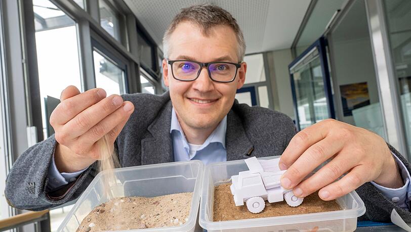 Luitpold Fried vom Start-Up-Unternehmen „Bind-X“ zeigt an einem Beispiel, wie mit einem speziellen Bindemittel aus ungefestigtem Sand, eine feste Verbindung entstehen kann, die zur Reduzierung von Staub auf unbefestigten Straßen führt.