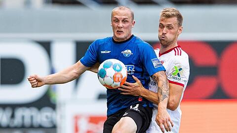 Paderborns Sven Michel (l) und Nürnbergs Asger Sörensen (r) kämpfen um den Ball.