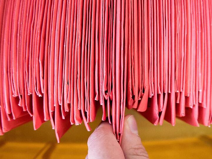 Eine Wahlhelferin sortiert eingegangene Wahlbriefe. Foto: Hauke-Christian Dittrich/dpa/Symbolbild