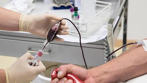 Eine Mitarbeiterin entnimmt einem Blutspender Blut. Foto: Christian Charisius/dpa/Archivbild