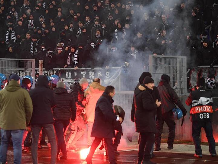 Frankfurter Fans randalieren während des Spiels im Fanblock und werfen Bengalos.
