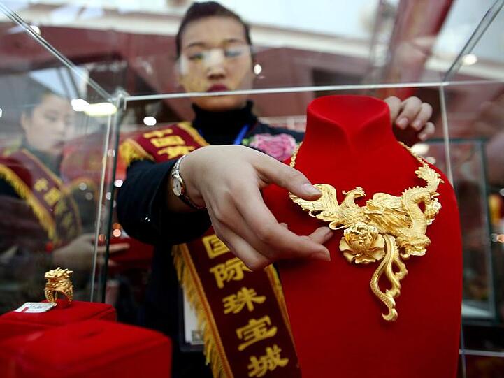 Eine Verkäuferin im chinesischen Shenyang bei der Präsentation von Goldschmuck.
