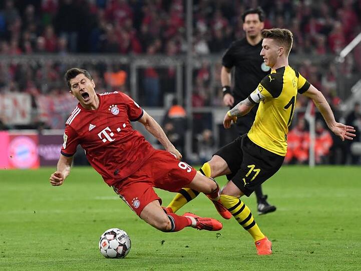 Münchens Robert Lewandowski (l.) und Marco Reus aus Dortmund kämpfen um den Ball. Foto: Sven Hoppe/Archivbild