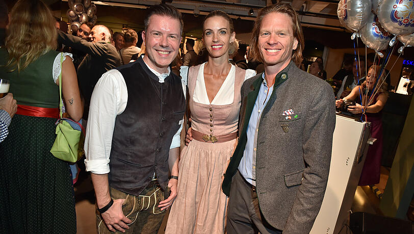 Feiern ausgelassen beim "Wiesn-Warm-up" bei Ludwig Beck: Christian Greiner (l., Vorstandsvorsitzender Ludwig Beck), Mike Kraus (r.) und Frau Coco.