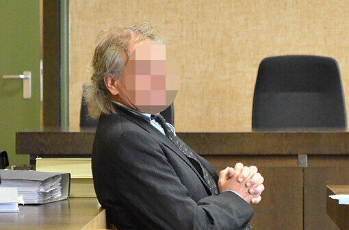 Mit gefalteten Händen sitzt Hans-Jochen Menzel vor dem Münchner Amtsgericht auf der Anklagebank.