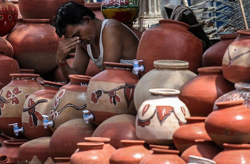 Ein Mann sackt erschöpft in sich zusammen: Eine Hitzwelle setzt den Menschen in Indien zu.