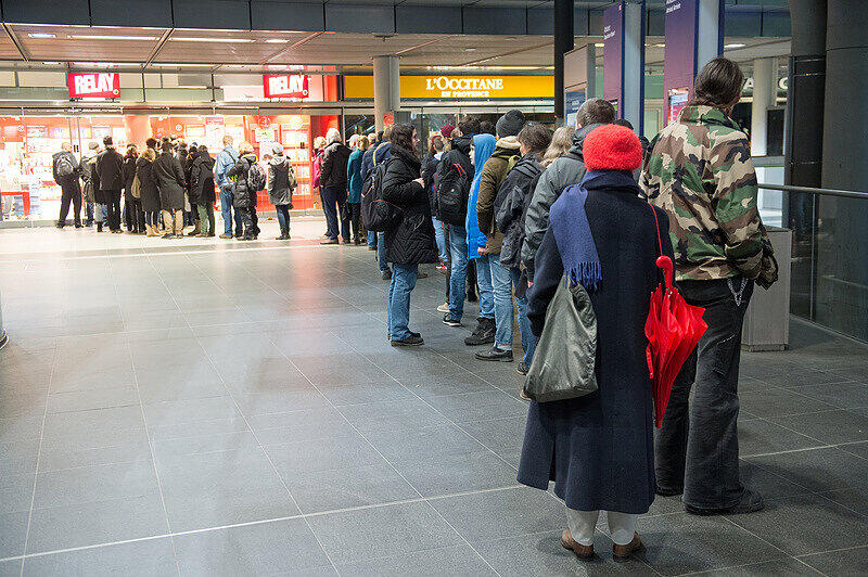 Passanten warten am 17.01.2015 im Hauptbahnhof in Berlin auf die Öffnung einer Bahnhofsbuchhandlung, um das franzöissche Satiremagazin Charlie Hebdo zu kaufen.
