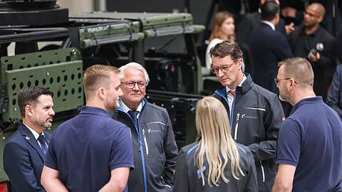 Rheinmetall-Chef Armin Papperger (Dritter von links) und NRW-Ministerpräsident Hendrik Wüst (zweiter von rechts) bei einem Rundgang durch die F-35-Produktionsanlage.