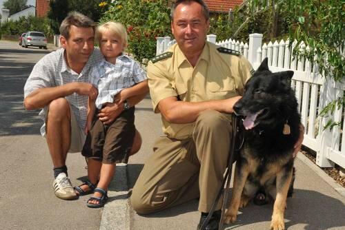 Der dreijährige Leander, sein Vater und Peter Wolf mit seinem Diensthund Tasco.