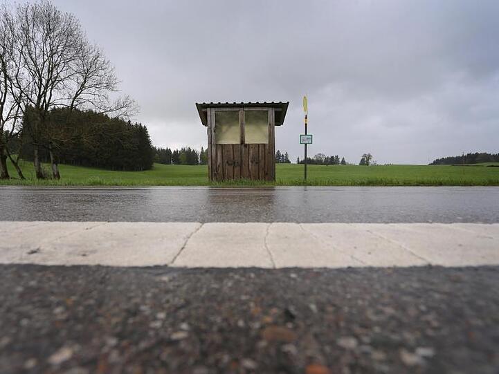 Eine Haltestelle der Regionalverkehr Oberbayern GmbH steht an einer Landstraße im Regen. Foto: Karl-Josef Hildenbrand/Archivbild