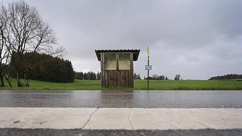 Eine Haltestelle der Regionalverkehr Oberbayern GmbH steht an einer Landstraße im Regen. Foto: Karl-Josef Hildenbrand/Archivbild