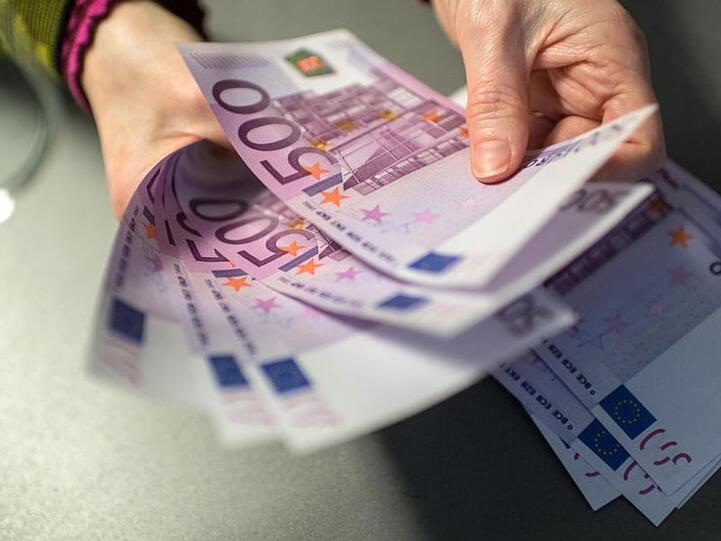 Die Mitarbeiterin einer Bank zählt 5000 Euro in 500-Euro-Scheinen ab. Foto: Matthias Balk/Archivbild