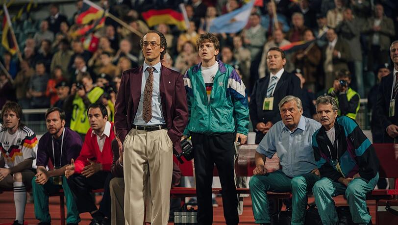 Andere Zeit, andere Mode: Franz Beckenbauer (Klaus Steinbacher, vorn) als Trainer der Weltmeistermannschaft von 1990.