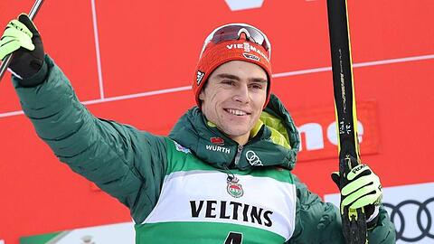 Der erstplatzierte Vinzenz Geiger jubelt auf dem Podium über seinen Sieg beim Weltcup in Val di Fiemme.
