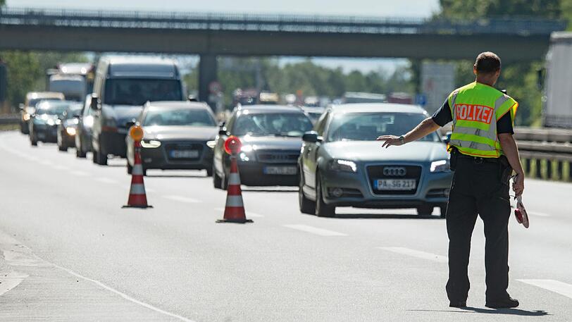 Ein Polizist winkt an der A 3 kurz hinter der deutsch-österreichischen Grenze nahe Pocking einen Audi-Fahrer zur Seite.