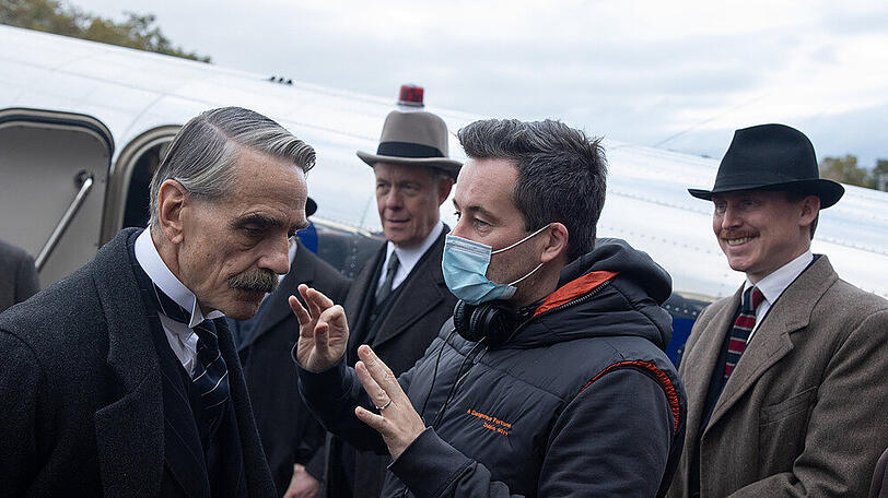 Christian Schwochow (mit Maske) führt bei der Verfilmung von "Munich" Regie, eine der Hauptrollen spielt Jeremy Irons (l.).