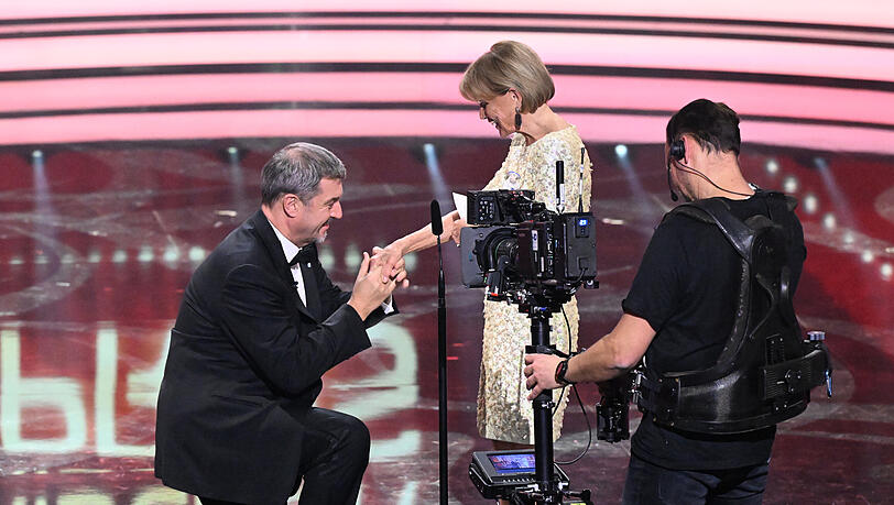Im Rahmen des 46. Bayerischen Filmpreises verleiht Markus Söder den "Preis des Ministerpräsidenten" an die Schauspielerin Uschi Glas – und geht dabei vor ihr auf die Knie. Im Rahmen des 46. Bayerischen Filmpreises verleiht Markus Söder den "Preis des Ministerpräsidenten" an die Schauspielerin Uschi Glas – und geht dabei vor ihr auf die Knie.