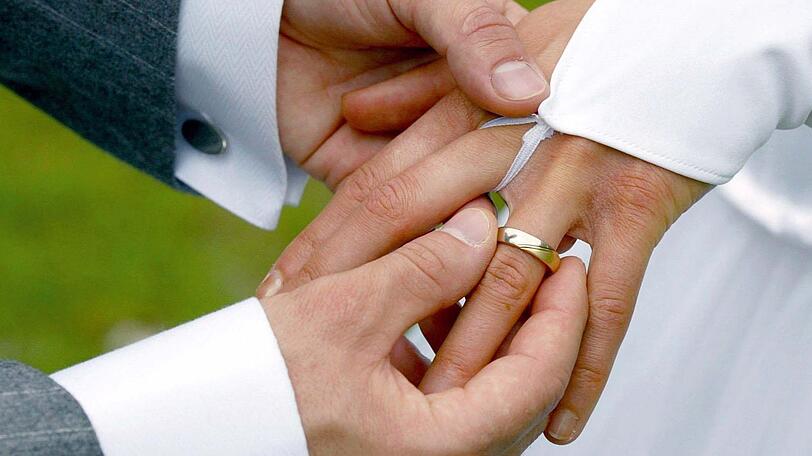 Der Bräutigam streift bei der Trauung seiner Braut den Ehering über den Finger. (Symbolbild)