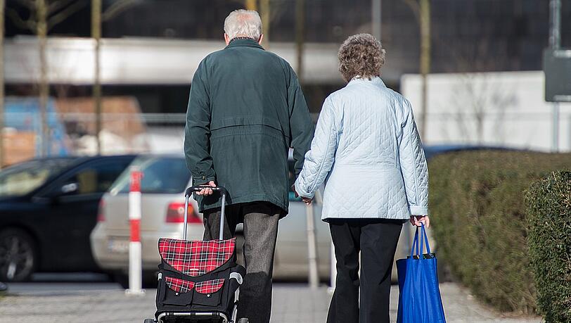 Ein älteres Paar geht mit Einkaufstrolley und -tasche durch die Straßen. (Symbolbild) Ein älteres Paar geht mit Einkaufstrolley und -tasche durch die Straßen. (Symbolbild)