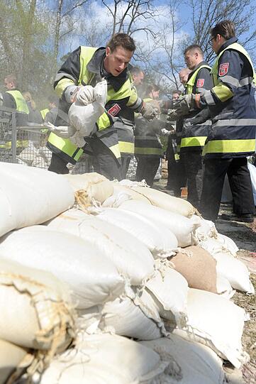 Helfer des THW München verladen am Samstag in München während einer Großübung Sandsäcke in ein Motorboot.