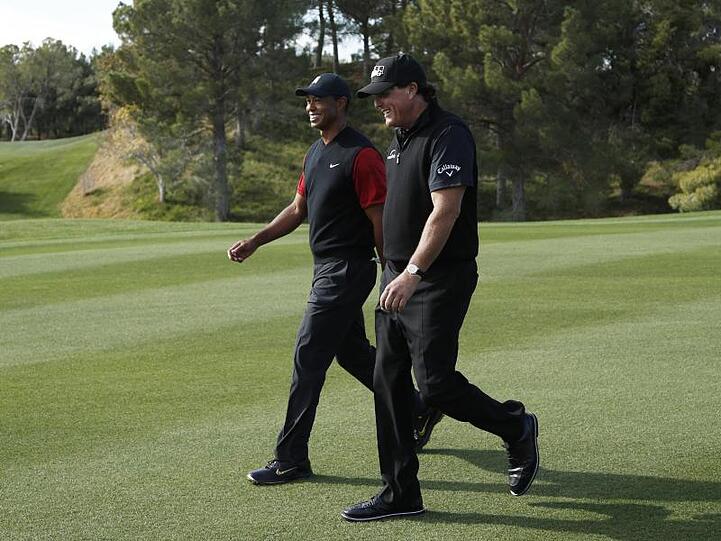Phil Mickelson (r) und Tiger Woods schreiten während ihres Privatduells auf dem Golfplatz Shadow Creek über das Grün.
