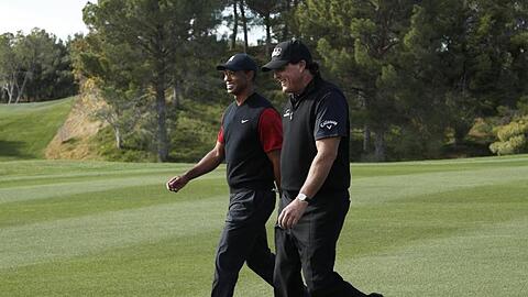 Phil Mickelson (r) und Tiger Woods schreiten während ihres Privatduells auf dem Golfplatz Shadow Creek über das Grün.