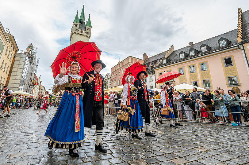 Teilnehmer des traditionellen Auszugs zum Gäubodenvolksfest gehen in Tracht durch die Innenstadt.