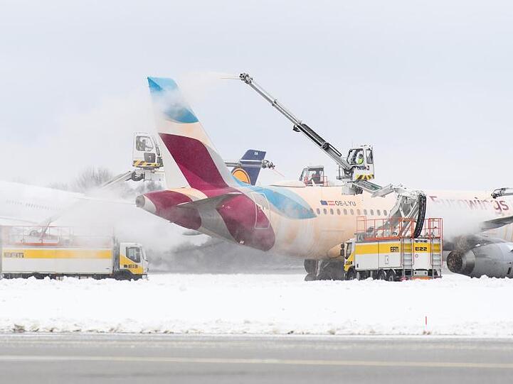 Ein Flugzeug der Airline "Eurowings" wird kurz vor dem Start nahe der Startbahn auf dem Taxiway am Flughafen enteist.