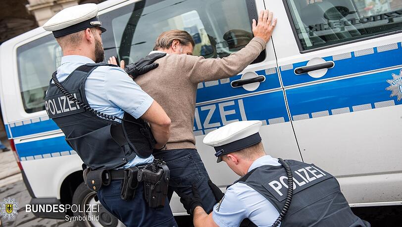 Beamte der Bundespolizei durchsuchen einen verdächtigen Mann. (Symbolbild)