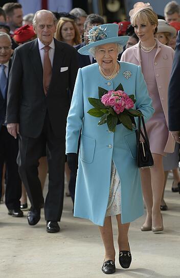 Blumen auf dem Kopf und in der Hand: Elizabeth II. in Hellblau.
