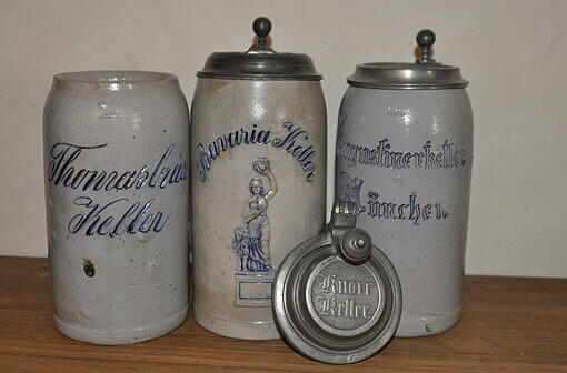 Steinalte Krüge:
Die drei der ältesten Krüge und der Deckel aus der Sammlung des Bier- und Oktoberfestmuseums sind Zeugnisse der Münchner Geschichte. Der Knorrkeller-Deckel stammt aus der Zeit um 1860, zwei Jahre später wurde die riesige Anlage an der Arnulfstraße von der Augustinerbrauerei gekauft und natürlich in Augustinerkeller umbenannt.
Gebaut wurde der Bierkeller schon Anfang des 19. Jahrhunderts, damals war sie noch im Besitz der Büchl-Brauerei. Der Augustinerkrug ist rund 110, der vom Thomasbräu rund 100 Jahre alt.