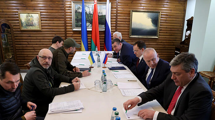 03.03.2022, Belarus, ---: Das von der belarussischen Staatsagentur BelTA verbreitete und von AP zur Verfügung gestellte Bild zeigt Mykola Totschyzkyj (l), stellvertretender Außenminister der Ukraine, Oleksij Resnikow (2.v.l), Verteidigungsminister der Ukraine, David Arachamija (3.v.l), Fraktionsvorsitzende der ukrainischen Diener des Volkes, Mychajlo Podoljak (4.v.l), Präsidentenberater, Boris Gryslow (5.v.r), Botschafter von Russland in Belarus, Leonid Slutsky (4.v.r), Vorsitzender des Ausschusses für internationale Angelegenheiten der russischen Staatsduma, Alexander Fomin (2.v.r), Vize-Verteidigungsminister von Russland, und Andrej Rudenko, Vize-Außenminister von Russland, als sie nehmen bei den Gesprächen nahe der polnisch-belarussischen Grenze teil.