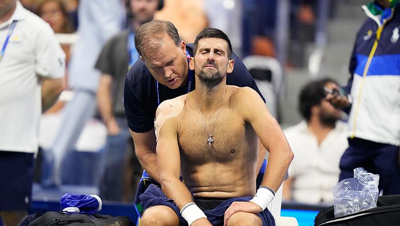 Im f&uuml;nften Satz wird Novak Djokovic am R&uuml;cken behandelt.