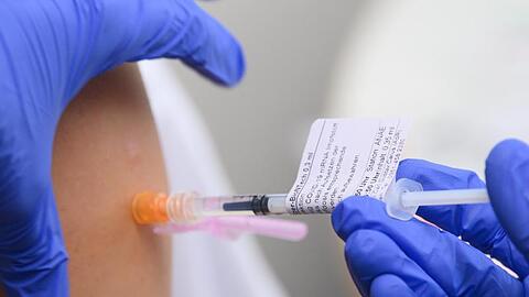 Eine Ärztin impft im Universitätsklinikum in Dresden einen Arztkollegen mit der dritten Impfung gegen das Coronavirus.