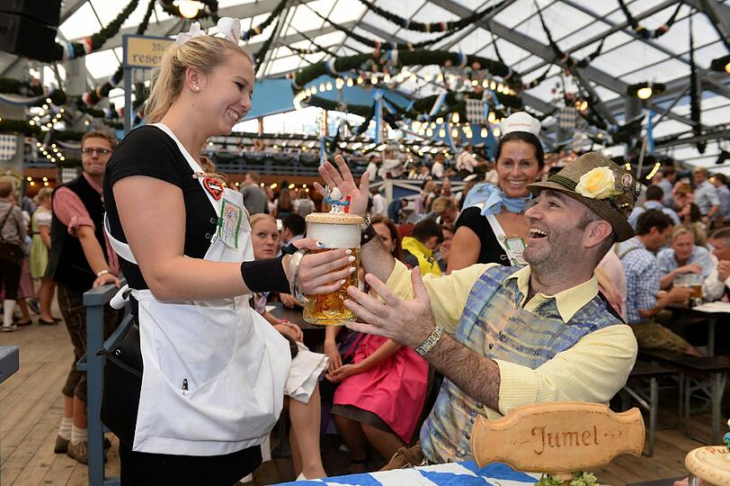 Armin Jumel bekommt von der Bedienung Laura auf dem Oktoberfest in München (Bayern) im Schottenhamel Festzelt ein Bier serviert.