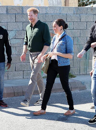 Zu einem Treffen mit Mitarbeitern der Organisation "Waves for Change" am Monwabisi Beach in Kapstadt erscheint Herzogin Meghan leger in schwarzer Jeans und lässiger Jeansjacke.