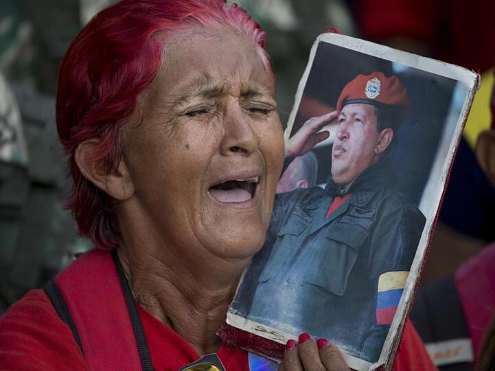 Eine Anhängerin von Venezuelas Präsident Maduro hält bei einer Kundgebung zur Unterstützung der Regierung ein Bild von Maduros Vorgänger, dem verstorbenen Präsidenten Chavez.