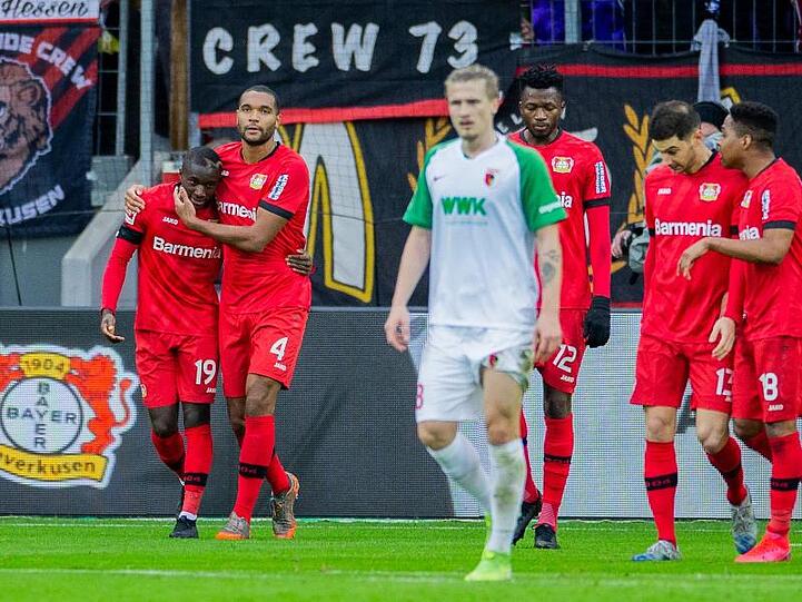 Leverkusens Moussa Diaby (l) wird nach seinem Treffer zum 1:0 von Teamkollege Jonathan Tah (2.v.l.) gedrückt.
