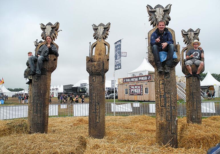 Besucher des Open Air Festivals in Wacken sitzen am 01.08.2013 auf Pfählen. Wer sechs Stunden auf einem Pfahl hockt, bekommt ein VIP-Bändchen.